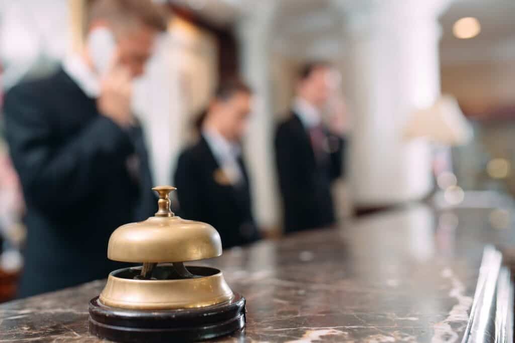 Service bell on a hotel reception counter with staff on duty
