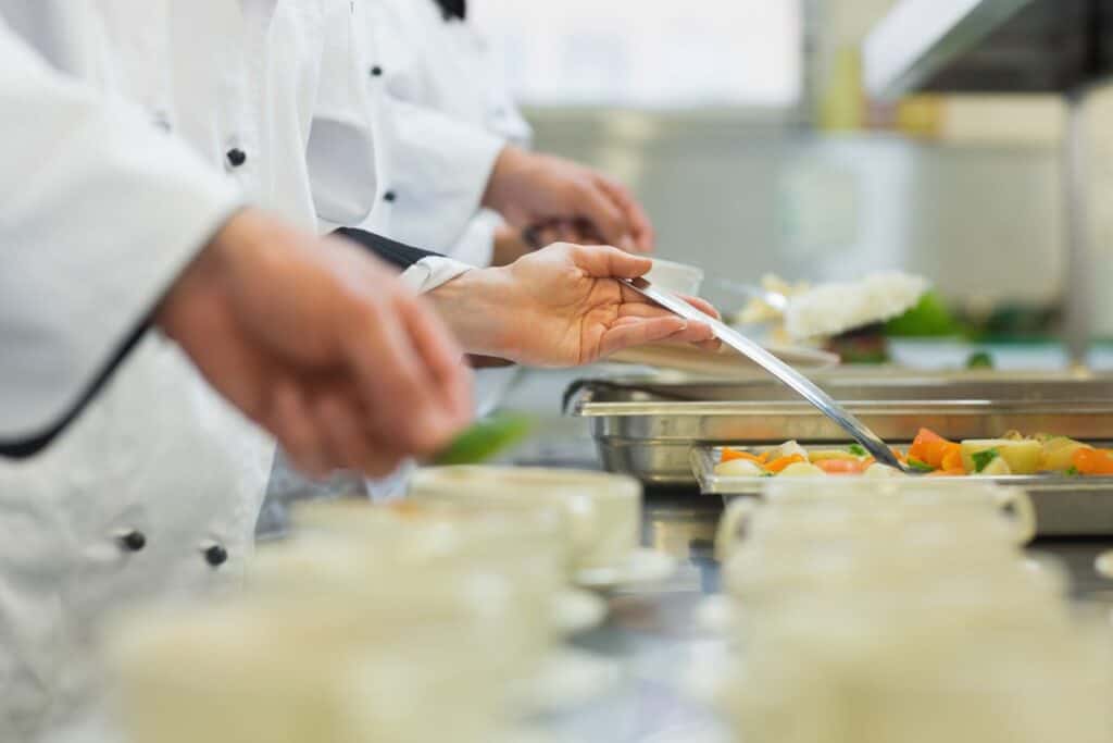 Kitchen team plating dishes on the line in a hotel kitchen